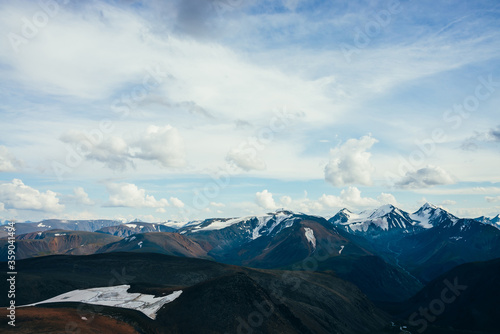 Aerial beautiful view to giant mountains and glaciers. Glacier on hillside. Meltwater streams flow from snowy rocks to highland valley. Wonderful scenery on high altitude. Atmospheric alpine landscape