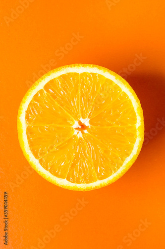 Orange on an orange background. The orange is cut in half. Photo above