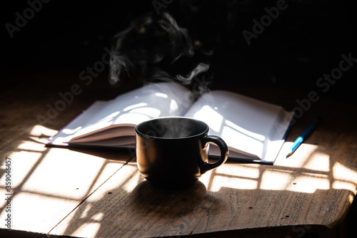 morning light refresh with black cup coffee aroma stream and wirting diary on wood table stock photo