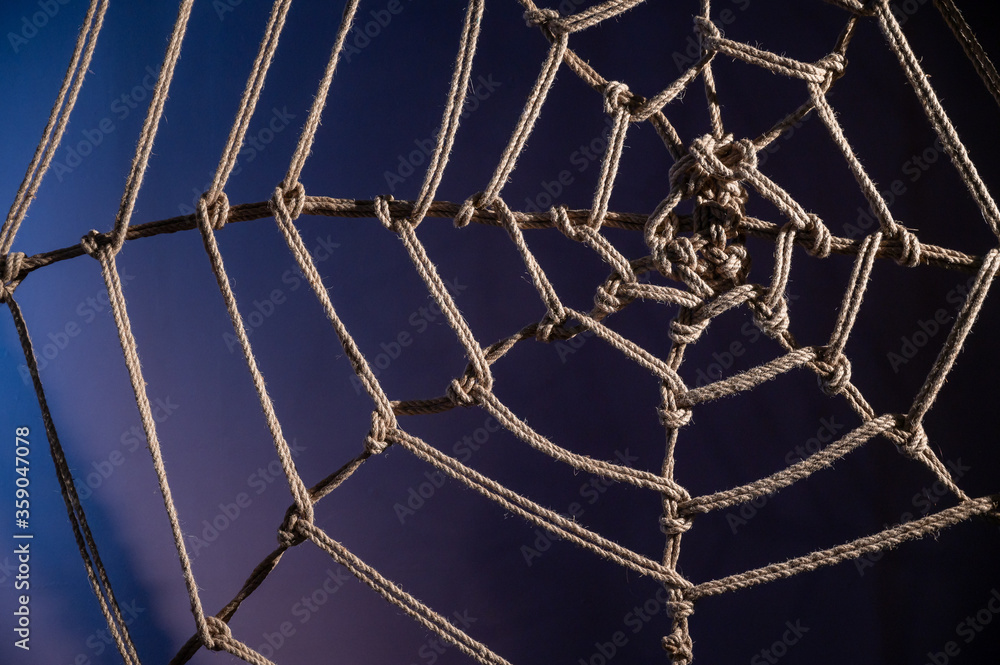 Japanese traditional technique of knitting shibari ropes in the form of a  spider web. No people. Part of the bedroom interior. BDSM. Stock Photo