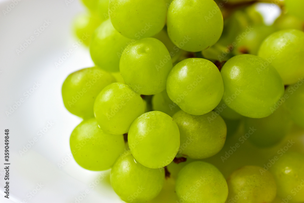 Green ripe grapes macrophotography on a white background Green ripe grapes macrophotography on a white background