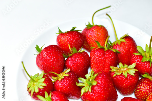 Berries of ripe and delicious strawberries on a white plate