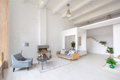 Luxury fashionable modern design studio apartment with a free layout in a minimal style. very bright huge spacious room with white walls and wooden elements. sitting area with fireplace © 4595886