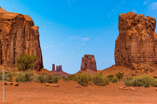North window framed by Elephant Butte and Cly Butte, showing Camel Butte and the Three Sisters Spires in Monument Valley tribal park in springtime