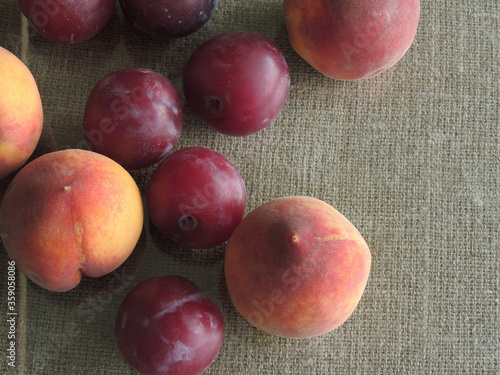 plums and peaches on the background of old burlap.