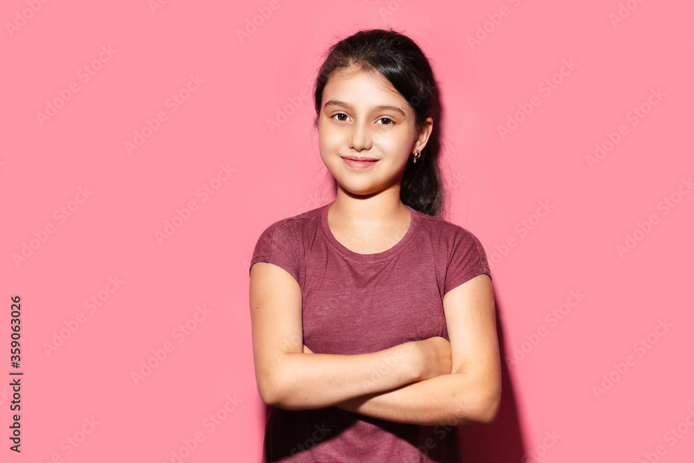 Studio portrait of smiling child girl with crossed arms on background of pastel pink color. Studio portrait of smiling child girl with crossed arms on background of pastel pink color.