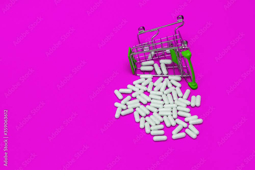 inverted trolley with purchased medicines, scattered pills on a violet background, medical concept