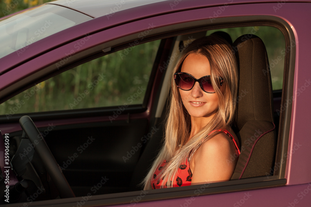 Pretty girl in a car. Attractive blonde woman driver looking out of window