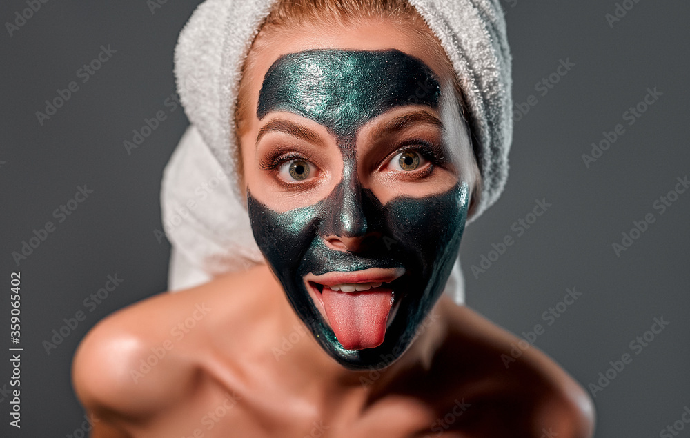 Beautiful woman with peel-off maskon a gray background. Beautiful woman with peel-off maskon a gray background.