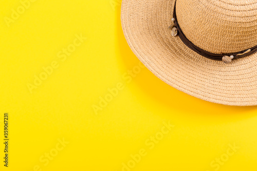 Top view of straw retro hat close-up on a yellow background. Summer concept.