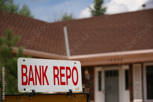 Bank Repo Sign on Home For Sale. The economy takes a turn for the worst with High Unemployment. Banks are repossessing homes when the owner can't pay the mortgage.
