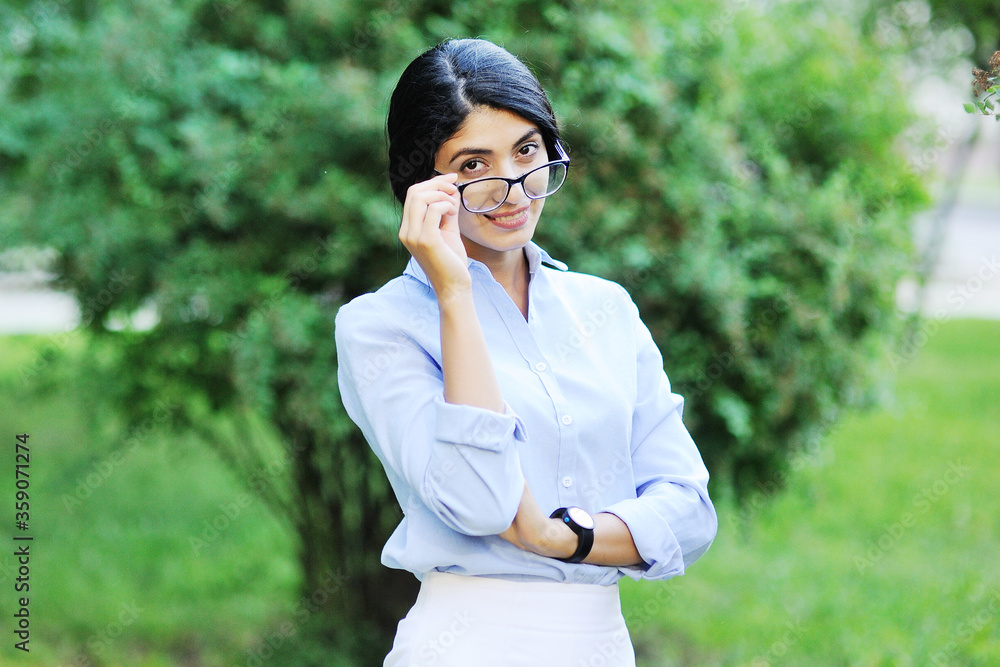 business portrait of a young business woman or teacher against the background of greenery and a Park. business portrait of a young business woman or teacher against the background of greenery and a Park.