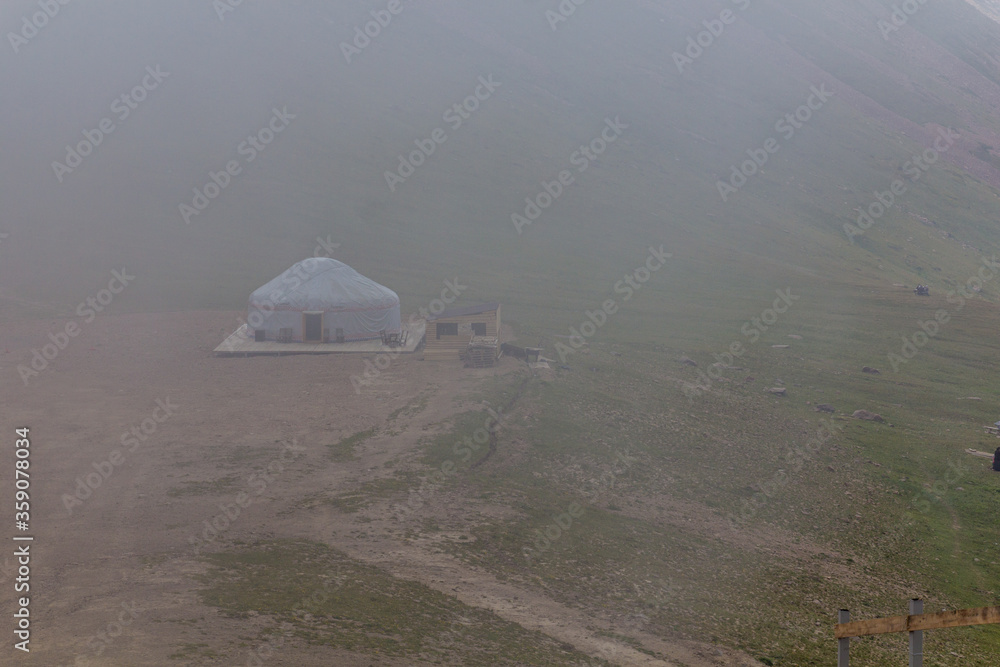 Yurt in a mist in Trans-Ili Alatau (Zailiyskiy Alatau) mountain range near Almaty, Kazakhstan