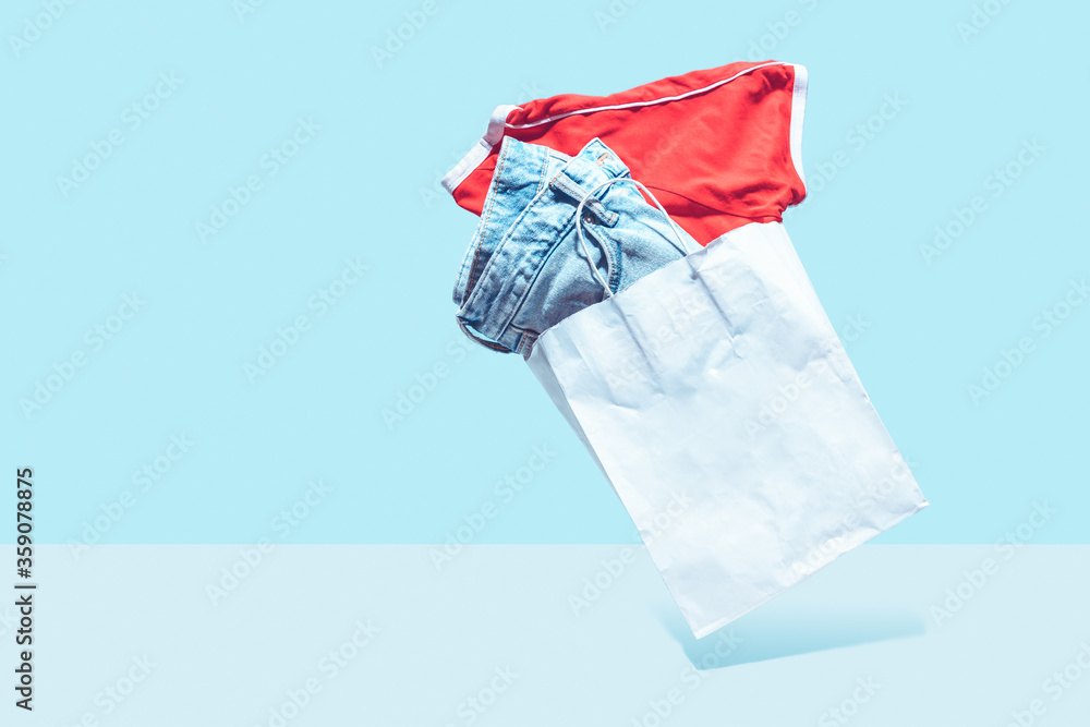 Flying shopping paper bag with purchases. Concept of consumerism, ease of shopping. Copy space trend pastel colors. Flying shopping paper bag with purchases. Concept of consumerism, ease of shopping. Copy space trend pastel colors.