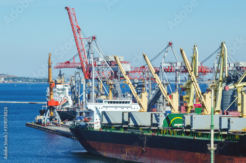 Port cargo crane loads a container onto a cargo ship in a seaport