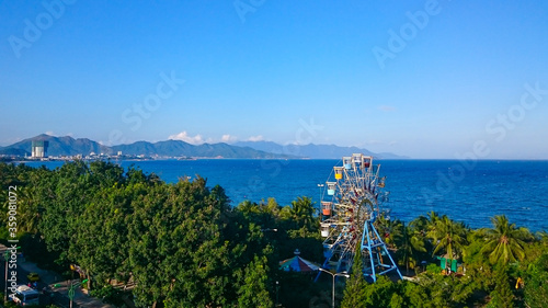 ferris wheel on the background of the sea with mountains in the background