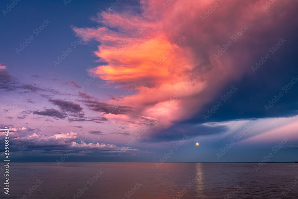 Moon over Sea Horizon with Golden Sunset Clouds