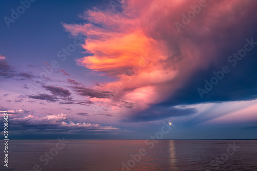 Moon over Sea Horizon with Golden Sunset Clouds