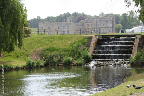 Leeds Castle stately home mansion near Ashford Kent in England with a river and weir in the foreground.  photo