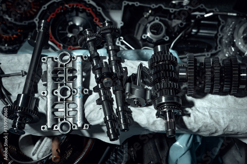 Disassembled fast motorcycle engine with visible transmission, locking valve, gear and piston parts. Sixteen valves and four cylinder motor.