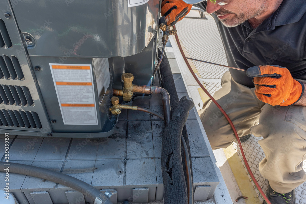 Soldering a copper pipe into air conditioner Stock Photo Adobe Stock