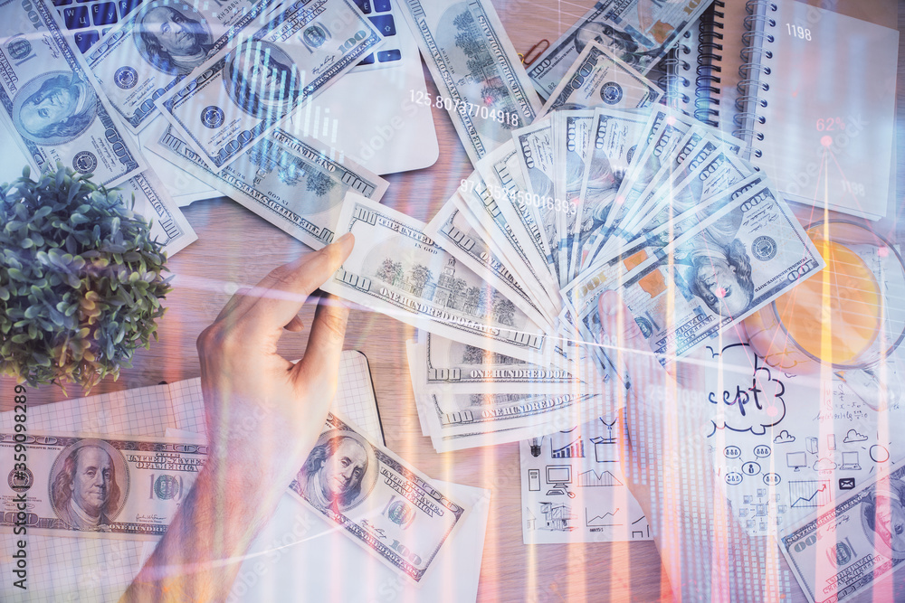 Multi exposure of financial graph drawing hologram and USA dollars bills and man hands. Analysis concept. Multi exposure of financial graph drawing hologram and USA dollars bills and man hands. Analysis concept.