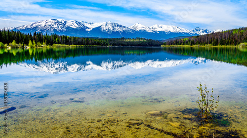 Patricia Lake with reflections of the snow capped peaks of the Rocky Mountains in Jasper National Park, Alberta, Canada