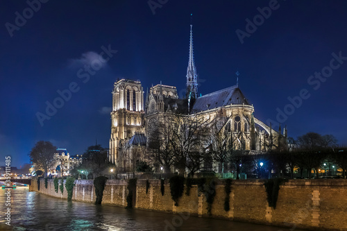 View over Seine onto illuminatred back side of Notre Dame de Paris at night in Paris France