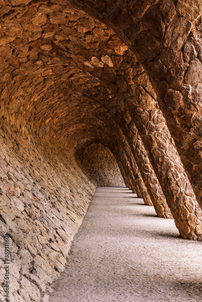 Stone walkway with a colonnade in the famous Antoni Gaudi Park Guell in Barcelona, Spain