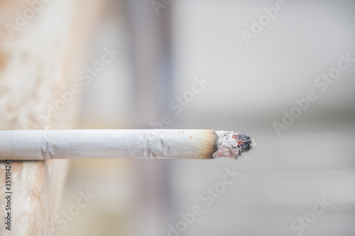 A cigarette placed on a wooden table.