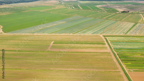 Agricultural land with with green crops and agricultural machinery top view. Countryside with farmland. © Alex Traveler