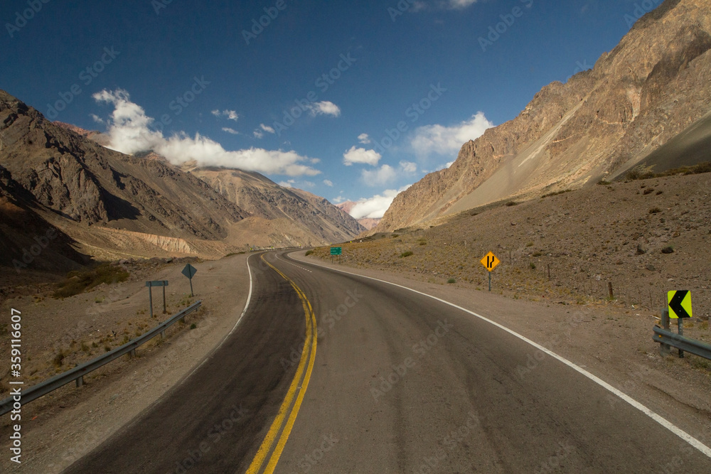 Travel. Rural highway. The curved asphalt road along the mountains and desert on the road to Aconcagua in Mendoza, Patagonia Argentina. 
