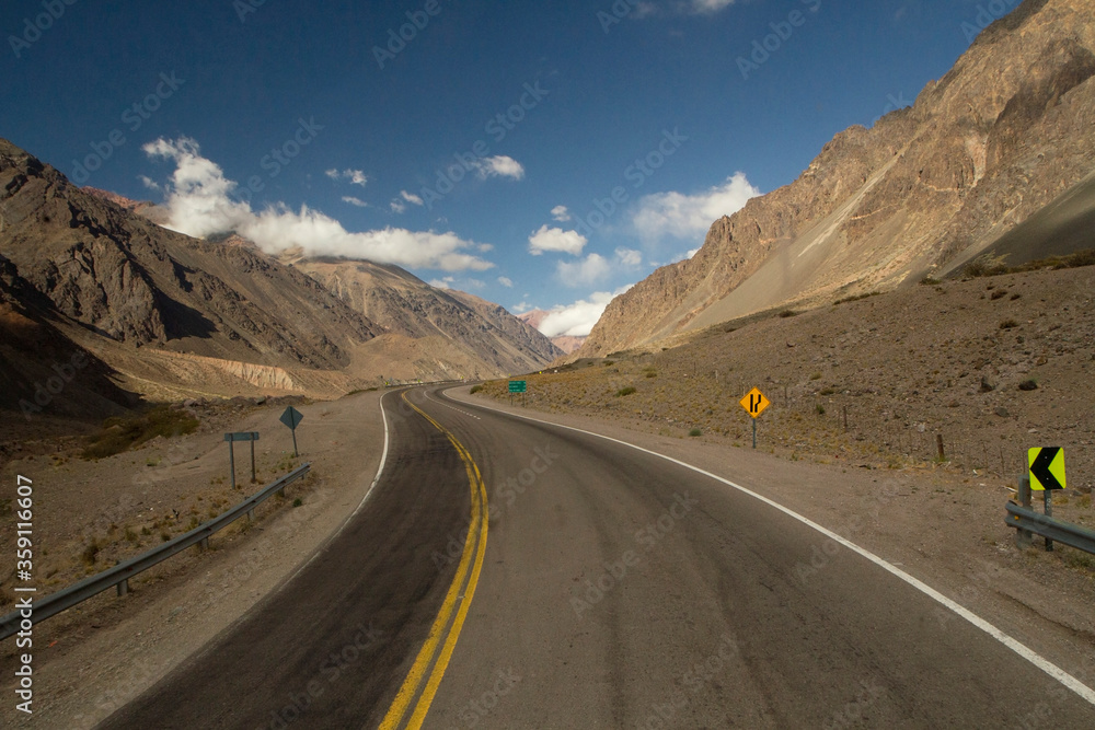 Travel. Rural highway. The curved asphalt road along the mountains and desert on the road to Aconcagua in Mendoza, Patagonia Argentina. Travel. Rural highway. The curved asphalt road along the mountains and desert on the road to Aconcagua in Mendoza, Patagonia Argentina.