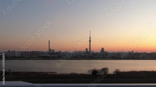 Train window with a clear view of Tokyo's evening sky