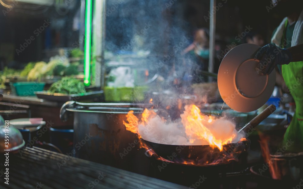 Chef is stirring vegetables in wok,Wok cooking a traditional stir fry. Street food in China, South-East Asia. Chef is stirring vegetables in wok,Wok cooking a traditional stir fry. Street food in China, South-East Asia.