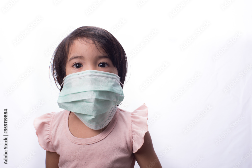 A female child wearing oversize medical face mask,isolated over white A female child wearing oversize medical face mask,isolated over white