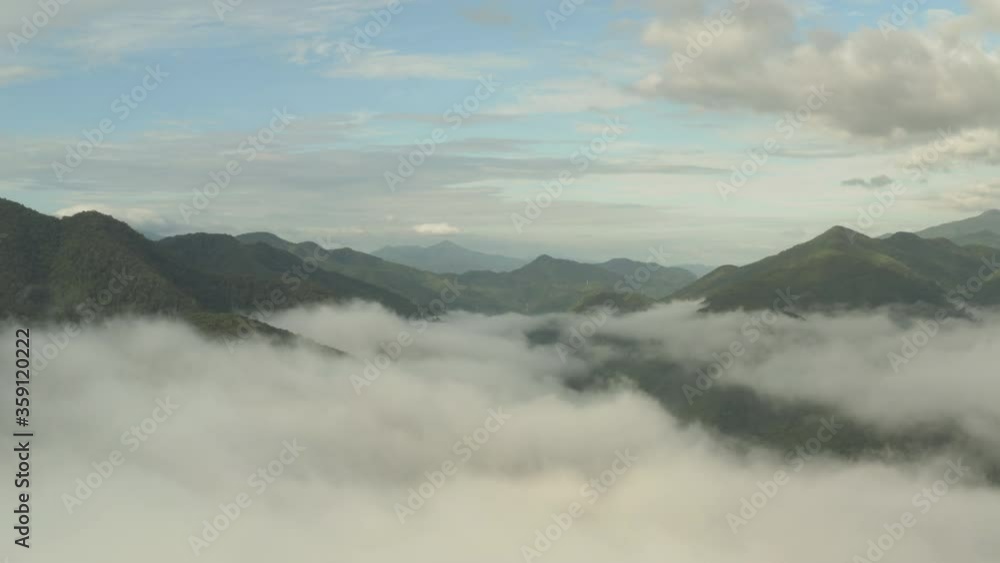 Flying through the clouds above green mountain tops. Aerial view of foggy rainforest Flying through the clouds above green mountain tops. Aerial view of foggy rainforest