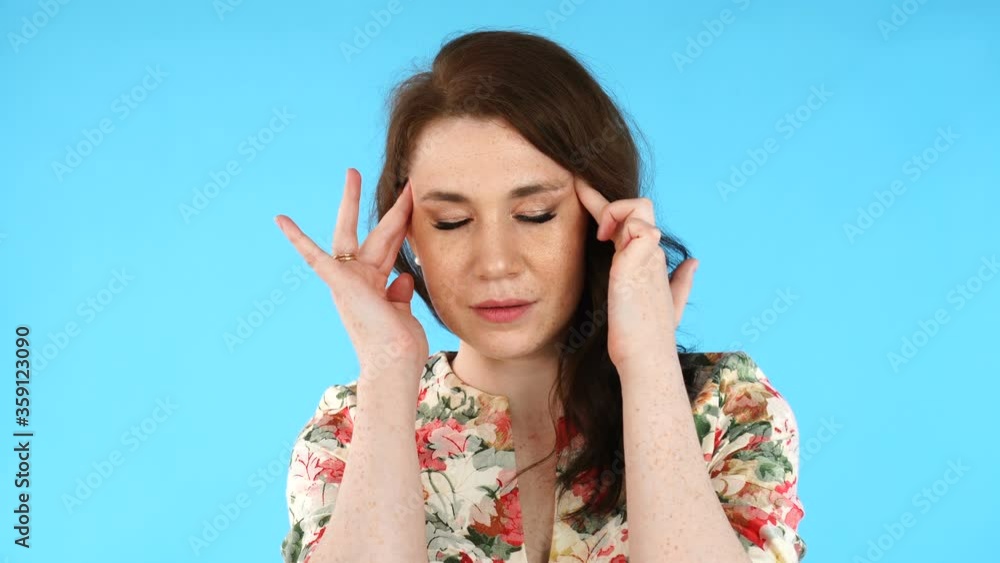 Beautiful european woman touching her temples feeling stress, on blue background