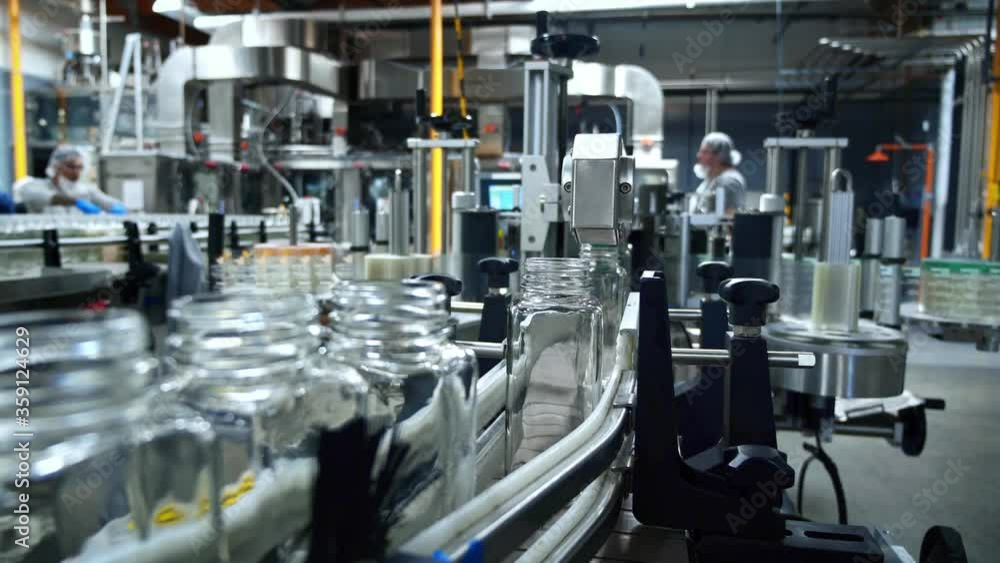 Juice bottling plant. Glass bottles on conveyor belt in beverage factory. Robotic automation line. packaging warehouse & processing facility. Juice bottling plant. Glass bottles on conveyor belt in beverage factory. Robotic automation line. packaging warehouse & processing facility.