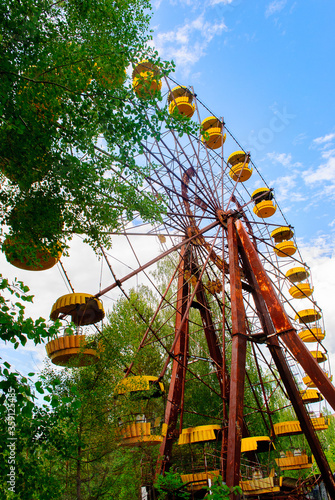 Observation wheel carousel with yellow cabins in the former musement park in Pripyat, a ghost town in northern Ukraine, evacuated the day after the Chernobyl disaster on April 26, 1986 photo