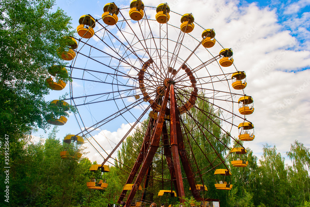 Observation wheel carousel with yellow cabins in the former musement park in Pripyat, a ghost town in northern Ukraine, evacuated the day after the Chernobyl disaster on April 26, 1986