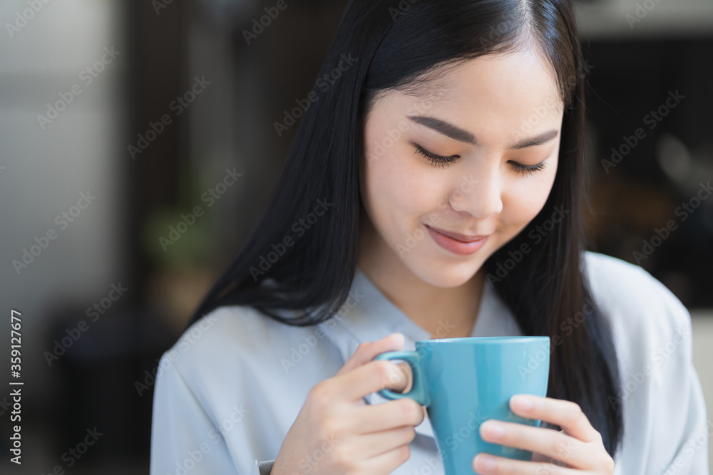 Beautiful asian woman drinking coffee and work from home in the morning. Smiling charming happy young female stay at home. Beautiful asian woman drinking coffee and work from home in the morning. Smiling charming happy young female stay at home.