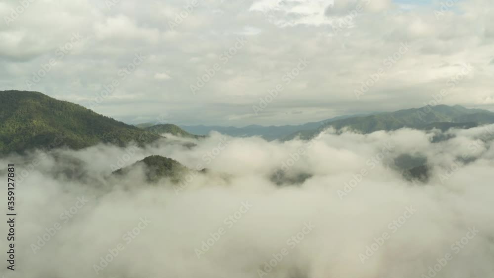 Flying through the clouds above green mountain tops. Aerial view of foggy rainforest Flying through the clouds above green mountain tops. Aerial view of foggy rainforest