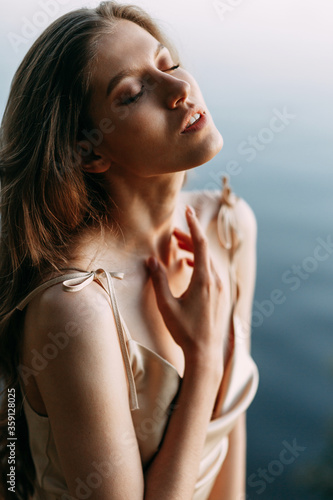 Beauty of a Woman's Face with healthy skin and a green plant. Female portrait at sunset.