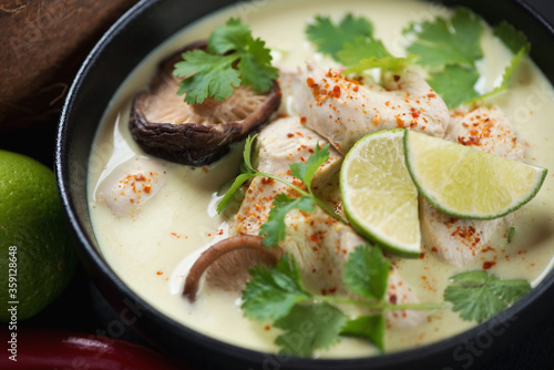 Close-up of thai tom kha gai or soup with chicken fillet, mushrooms and coconut milk, selective focus