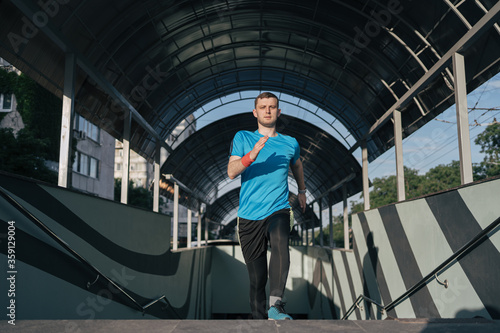 Wallpaper Mural Young man running upstairs on city stairs. Fitness, sport, people, exercising and lifestyle concept Torontodigital.ca