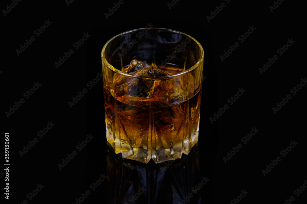 Glass of whiskey with ice on a black background Glass of whiskey with ice on a black background