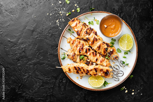 Grilled chicken satay skewers with peanut butter sauce.