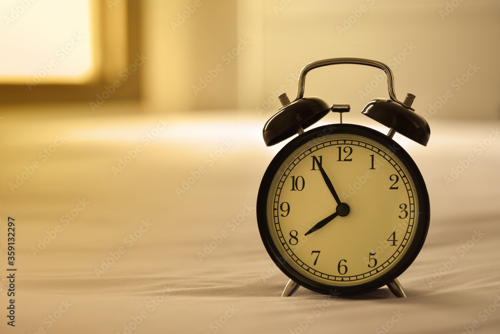 Alarm clock on bed in the morning Alarm clock on bed in the morning