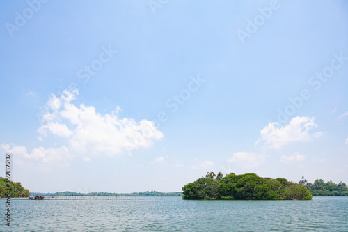 Tropical island in the middle of a sea lake on a sunny day in Sri Lanka.